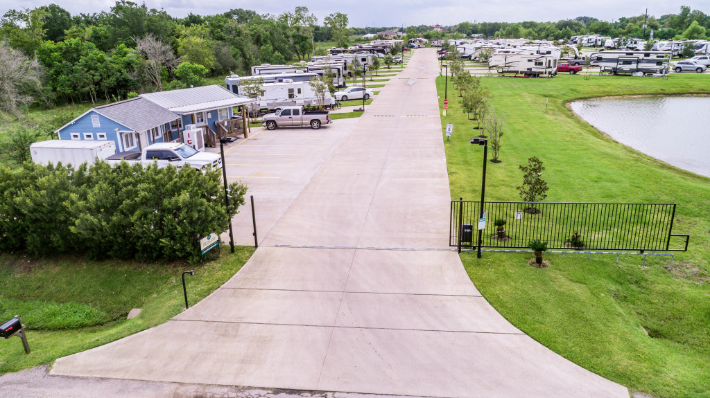 RV Park with gated entrance, lush green grass and many parking spaces.